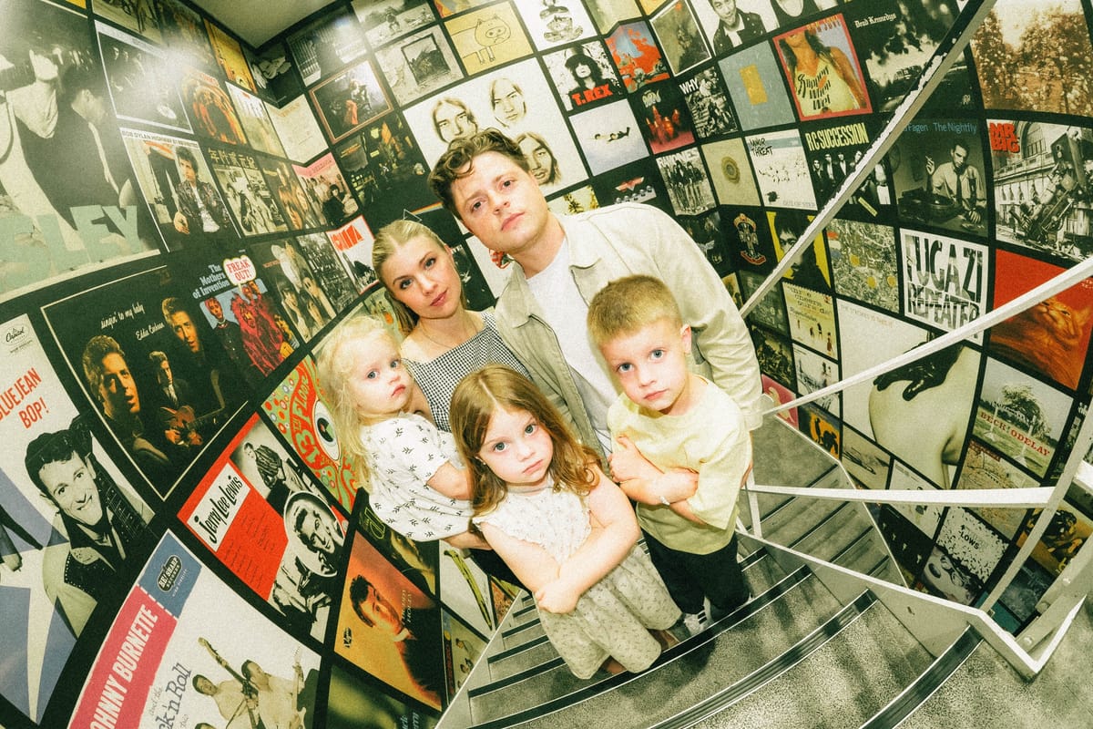 Andy Sommer, Morgan and their three kids standing in a Tokyo alley lined floor to ceiling with music posters