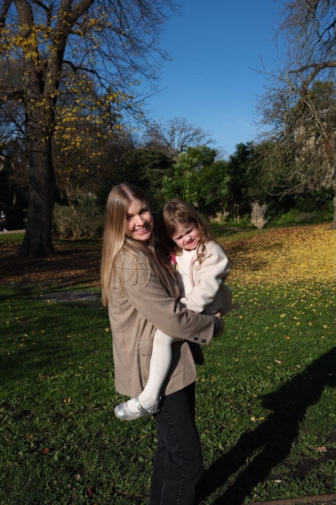 A parent holding one of the children in a park.