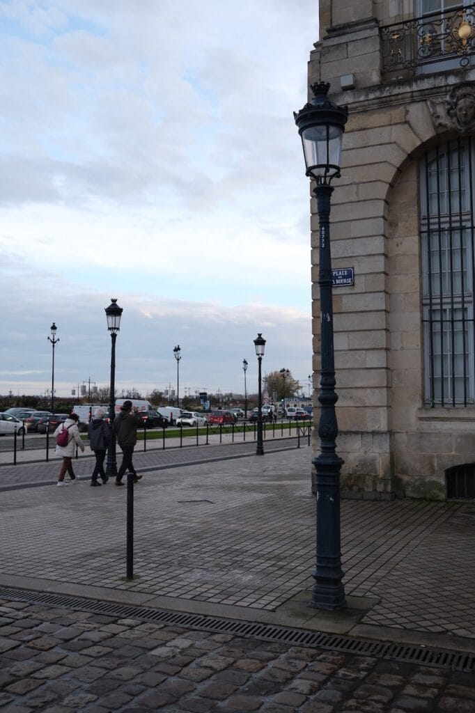 A town promenade lined with lampposts on an overcast day.