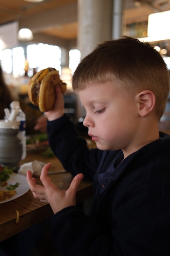 A young boy eating a pastry.
