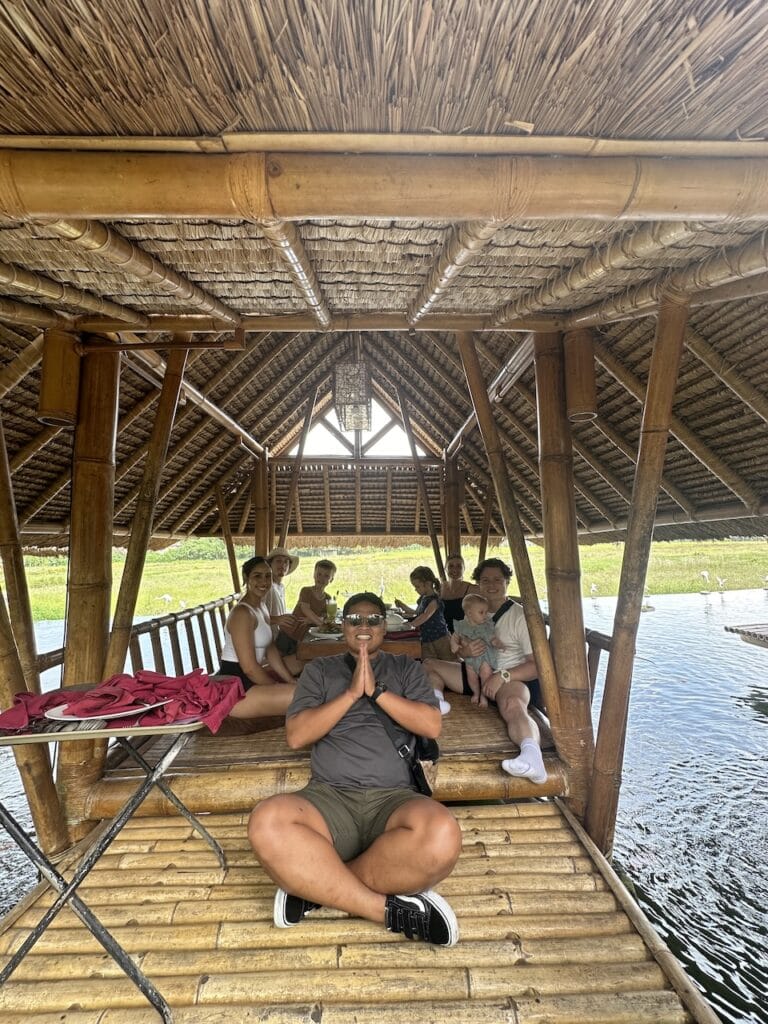 Children resting under a bamboo pavilion above the rice fields.
