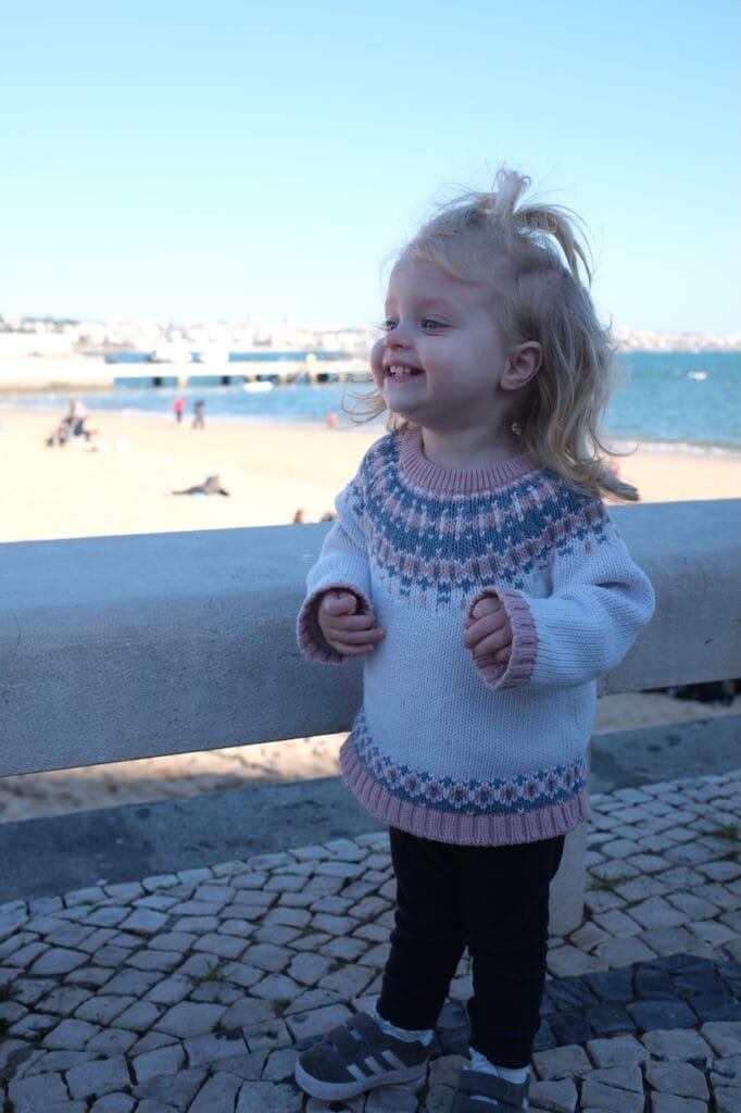 A young girl on the beach near the water.