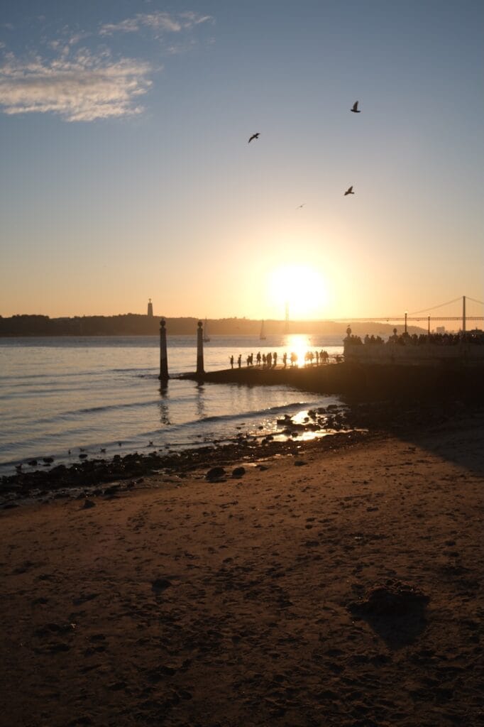Sunset over the water along a rocky coastline.
