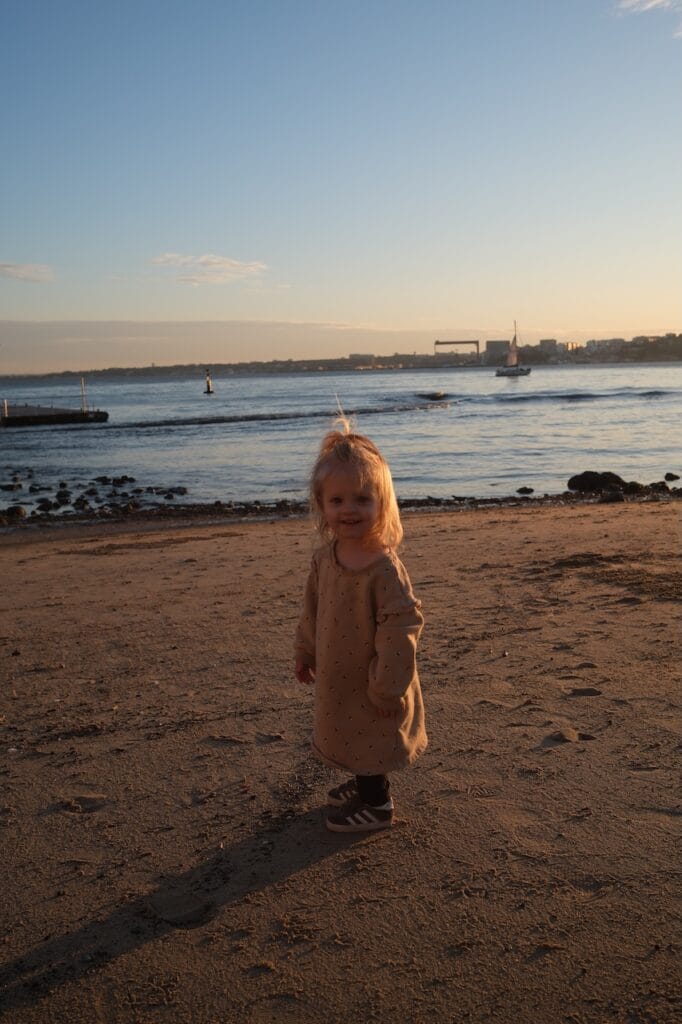 A young girl on the beach at sunset.