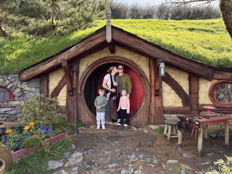 The family in front of a Hobbit hole at Hobbiton in New Zealand.