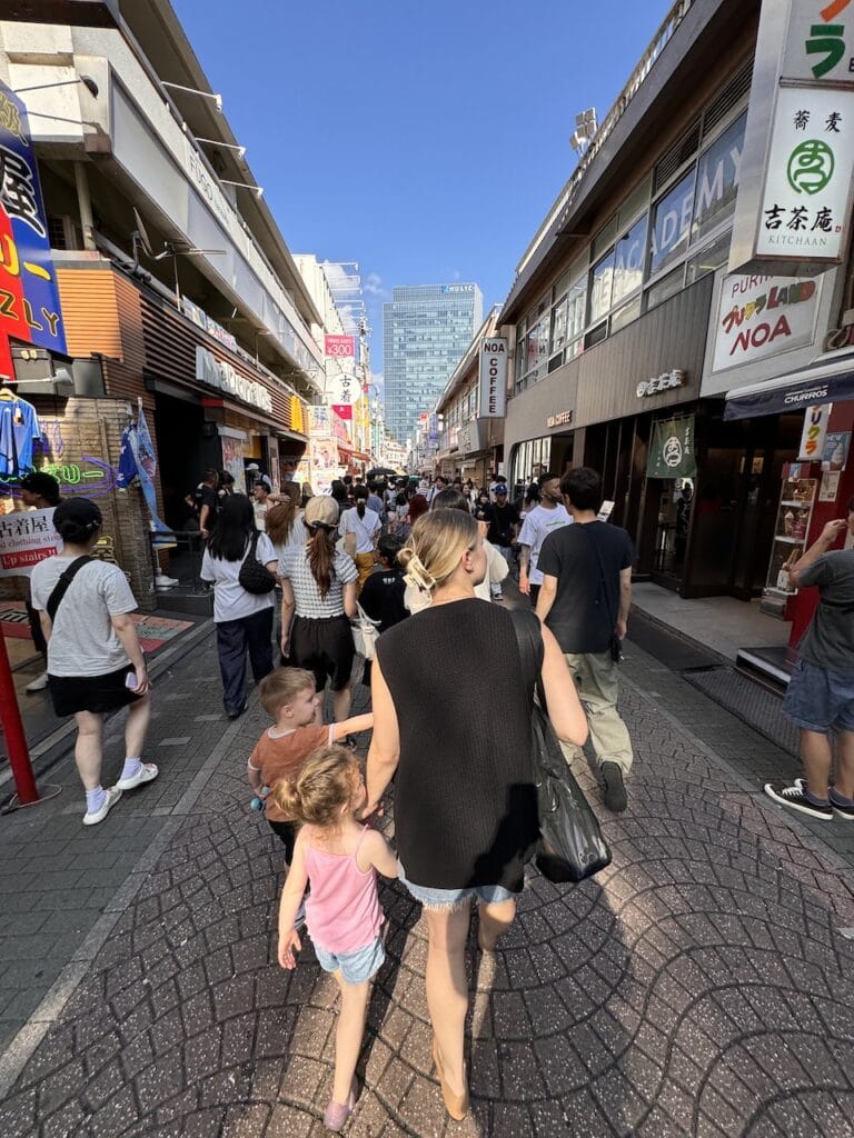 Crowds and children on a busy shopping street in Japan.