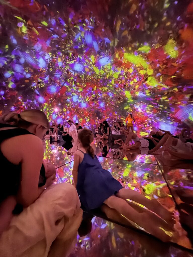 A child inside a colorful immersive light art installation.