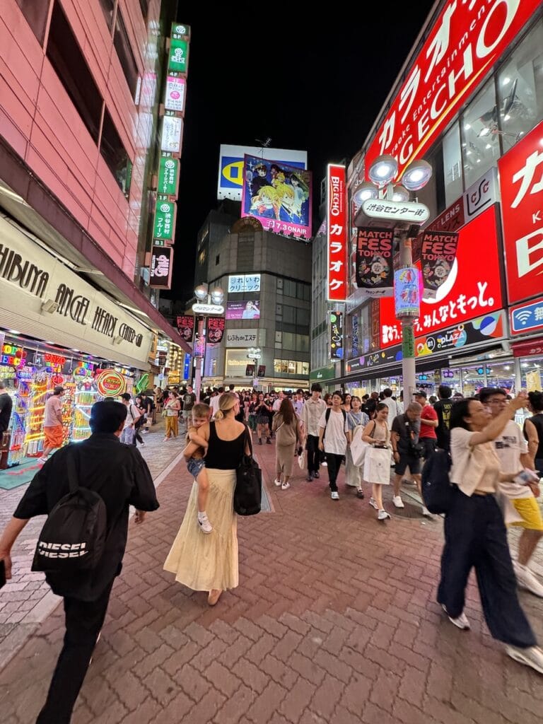 A bright neon city street in Japan at night.